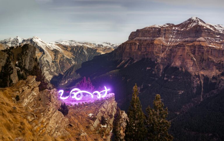 Captivating light art contrasts with the majestic Pyrenees landscape in Aragon, Spain.